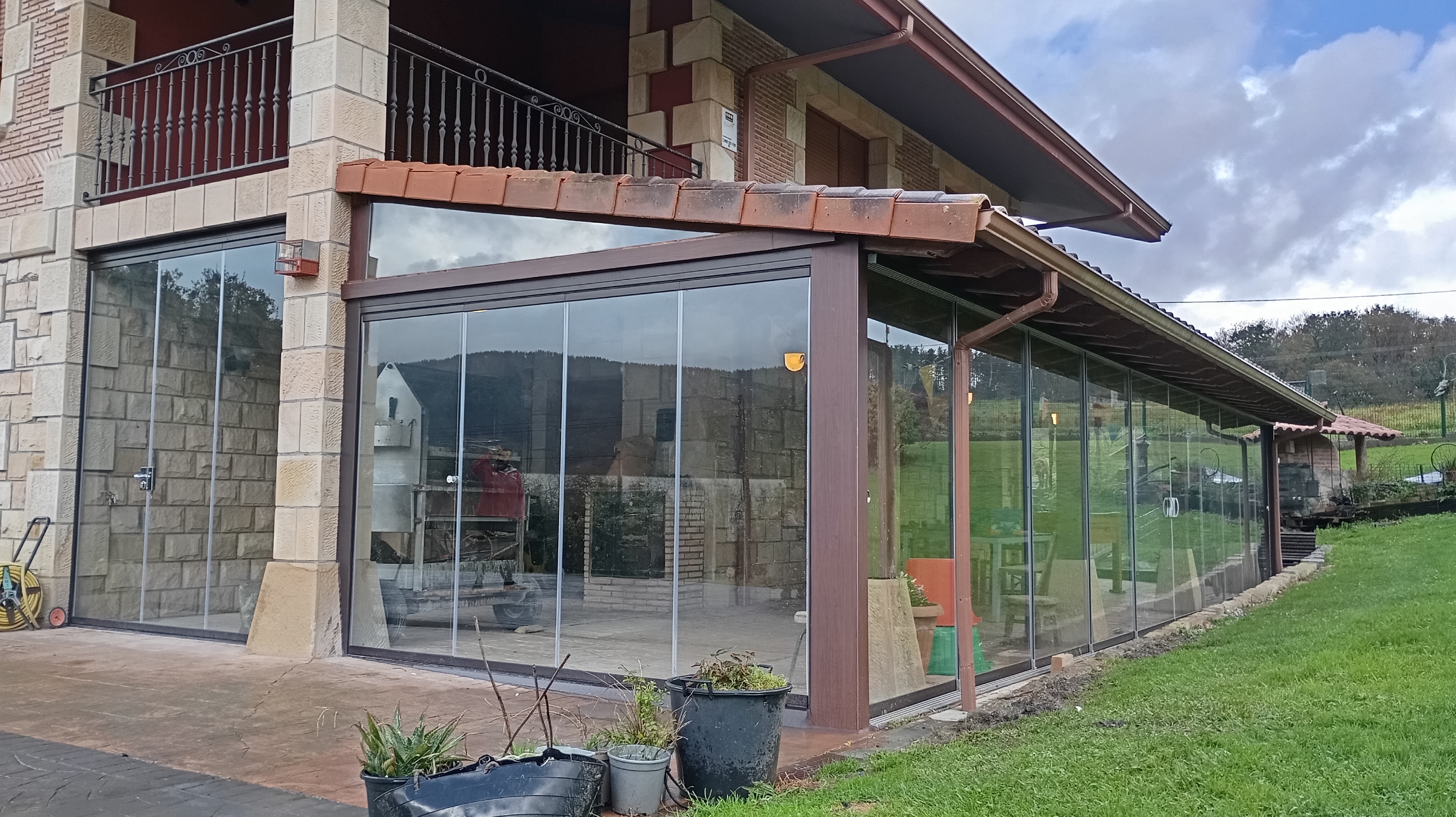 Cerramiento de correderas deslizantes de aluminio blanco y vidrio, con el monte al fondo